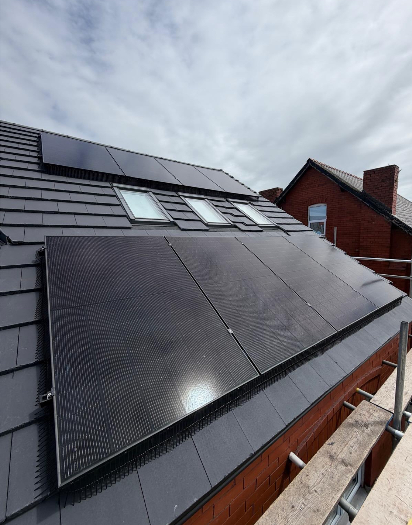 Large solar array on the rear roof of a red brick home