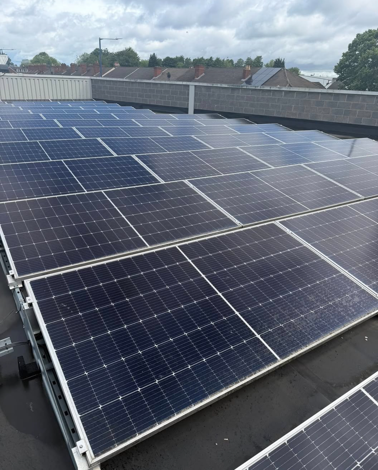 Flat commercial roof covered with angled solar panel rows