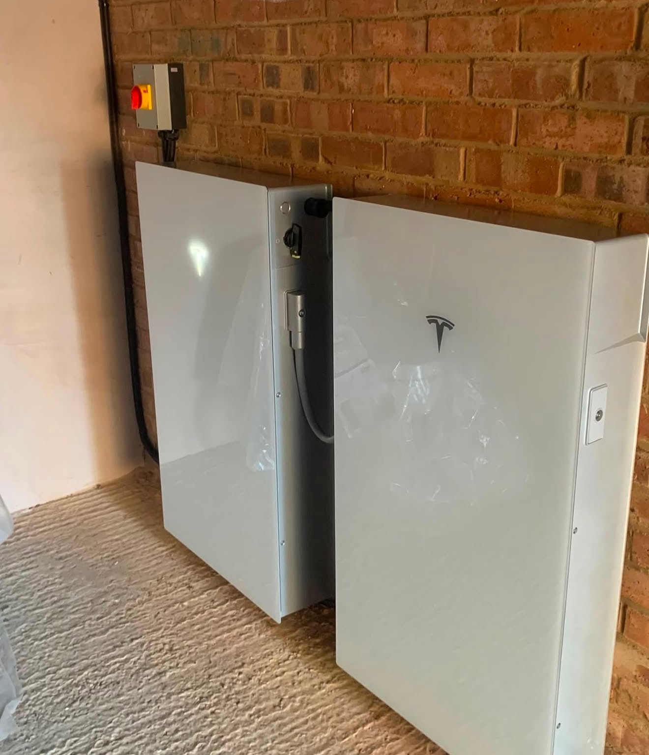 Two home batteries installed in a garage during commissioning